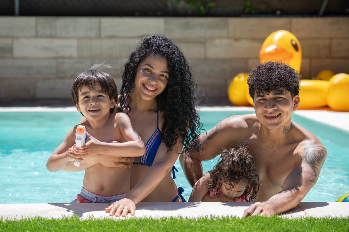 Happy latin family enjoying day at the pool