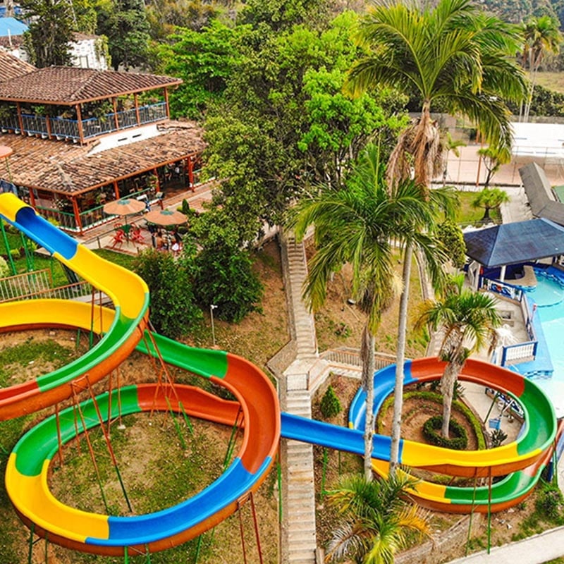 Tobogán acuático de 100 metros en Antioquia Tropical Club con piscinas y áreas verdes tropicales